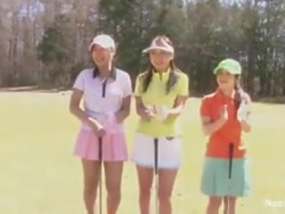 Schön asiatisch teenager mädchen spielen ein spiel von streifen golf